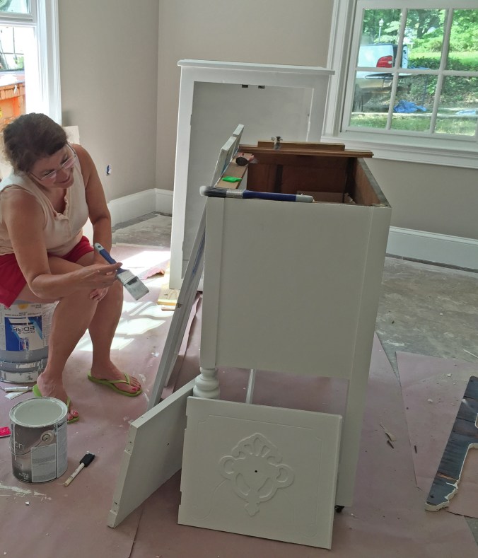 Mom carefully painting both hall bathroom cabinets -- what a life saver!